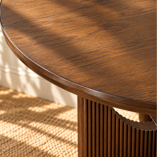 Load image into Gallery viewer, Sylvia round dining table in Natural Brown Walnut with sculptural fluted pedestal base and distinctive circular cutouts.
