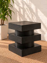 Load image into Gallery viewer, Tatum charcoal wood side table with stacked square platforms and rounded cylindrical center sections
