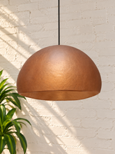 Load image into Gallery viewer, Tayla hanging lamp in terracotta with a wide dome-shaped textured fiber cement shade and black suspension cord.
