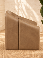 Load image into Gallery viewer, Image 9 of 15: Tessa sculptural accent chair in Toasted Camel vegan leather with curved arm, open backrest, and low profile
