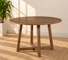 Load image into Gallery viewer, Image 1 of 4: Tori 47-inch round dining table in Natural Walnut with sculptural cross base and rounded tabletop edge


