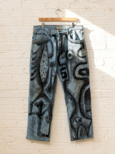 Load image into Gallery viewer, Cesar Platero hand-painted blue denim jeans with large black and gray abstract shapes, circles, lines, and expressive graphic artwork.
