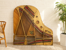 Load image into Gallery viewer, Deconstructed piano harp with gold-tone cast metal frame, exposed strings, tuning pins, red felt, and aged patina


