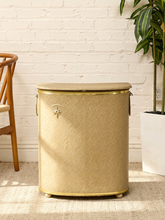 Load image into Gallery viewer, Vintage beige Atomic Age clothes hamper with rounded lid, brass-tone trim, textured patterned finish, and metal starburst accent
