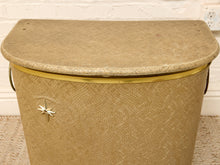 Load image into Gallery viewer, Vintage beige Atomic Age clothes hamper with rounded lid, brass-tone trim, textured patterned finish, and metal starburst accent
