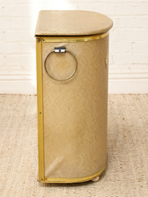 Load image into Gallery viewer, Vintage beige Atomic Age clothes hamper with rounded lid, brass-tone trim, textured patterned finish, and metal starburst accent
