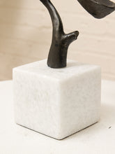 Load image into Gallery viewer, A close-up of a modern abstract sculpture featuring a dark, branch-like metallic form rising from a white marble cube base, set against a neutral cream background.
