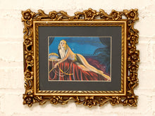 Load image into Gallery viewer, Art Deco-style portrait of woman in red gown with feather fan and pearls in an ornate gold-tone floral frame with black mat
