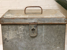 Load image into Gallery viewer, A vintage galvanized metal paint canister with a rusted handle and latch, featuring the embossed brand name 'Pintour Paints' on the front, set against a white brick wall background.
