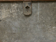 Load image into Gallery viewer, Close-up of a distressed, weathered gray metal surface with embossed cursive text reading 'Palmolive' and a rusted metal latch near the top.
