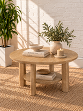 Load image into Gallery viewer, Image 2 of 5: Vito round coffee table in Sunwashed Oak with sculpted legs, circular lower shelf, and natural wood-grain finish

