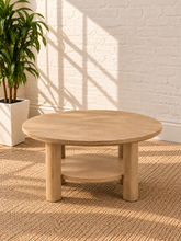 Load image into Gallery viewer, Image 3 of 5: Vito round coffee table in Sunwashed Oak with sculpted legs, circular lower shelf, and natural wood-grain finish
