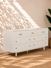 Load image into Gallery viewer, Image 3 of 4: Yvette 7-drawer dresser in Chalk White with polished gold details and elevated legs
