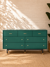 Load image into Gallery viewer, Image 2 of 4: Yvette 7-drawer dresser in Juniper Green with polished gold details and elevated black and gold legs
