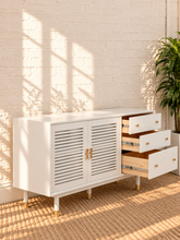 Load image into Gallery viewer, Image 4 of 4: Yvette TV stand in Chalk White with three drawers, two-door storage cabinet, gold details, and elevated legs
