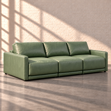 Load image into Gallery viewer, Image 7 of 18: Simulated Orinda three-piece sofa, left side angle in sage green Sequoia Rainforest leather, without accent pillows, in the Sunbeam white brick setting.
