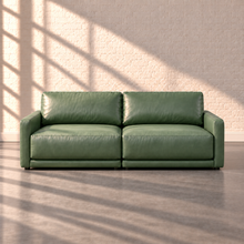 Load image into Gallery viewer, Image 1 of 3: Simulated Orinda two-piece loveseat combining left- and right-arm chair modules in sage green Sequoia Rainforest leather, shown front-on against white brick with natural sunlight.
