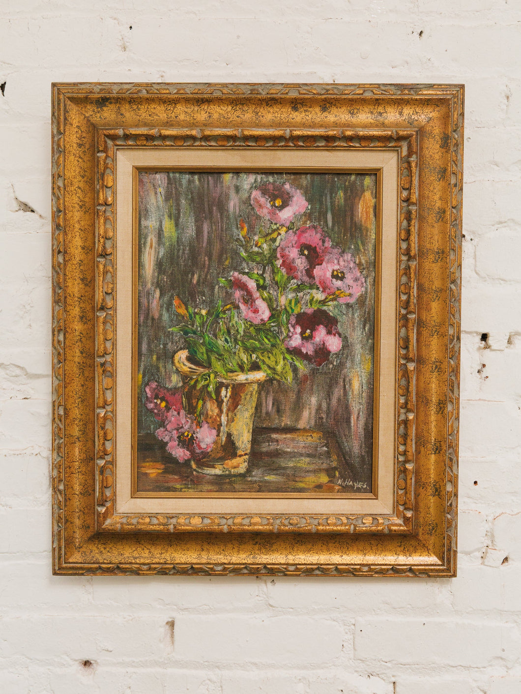Painting of flowers in a vase, framed in an ornate gold frame