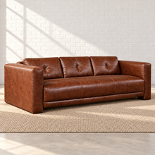 Load image into Gallery viewer, Image 2 of 6: Simulated left front angle of the Sullivan sofa in Crystal Ranch brown leather, showing the upholstered outer arm, button-tufted back and continuous seat in the Sunbeam setting.
